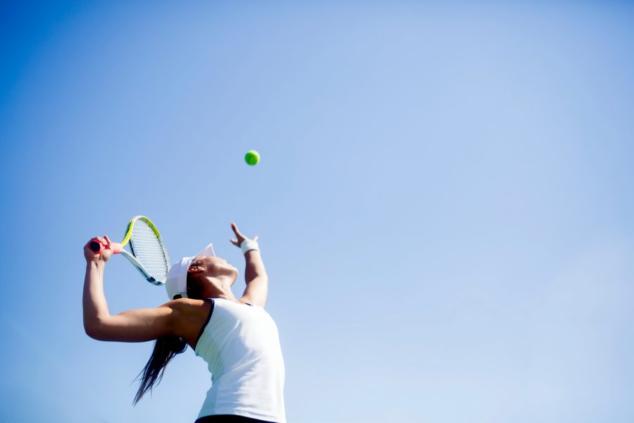 テニスのサーブをする女性